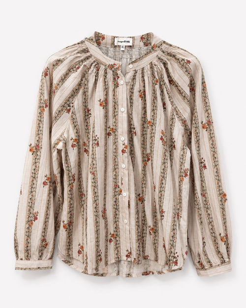 A long-sleeve button-up blouse with a beige and brown vertical stripe pattern accented by small orange and green floral motifs, displayed flat against a light gray background.